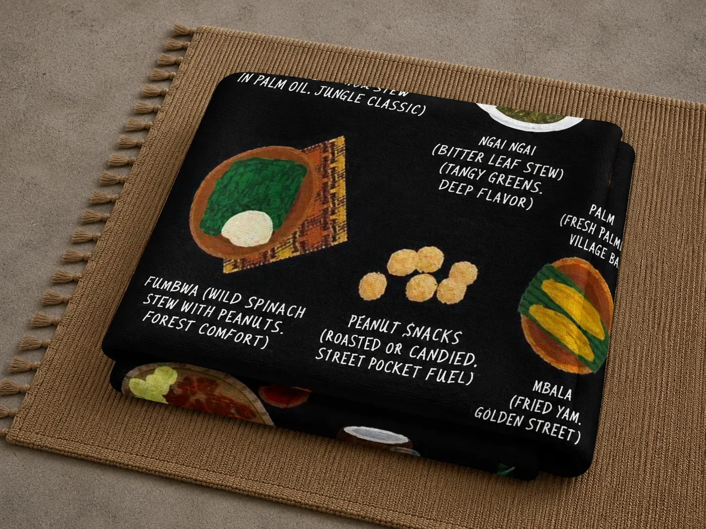 Folded black Congo food blanket showing fumbwa, ngai ngai and peanut snacks on a woven mat