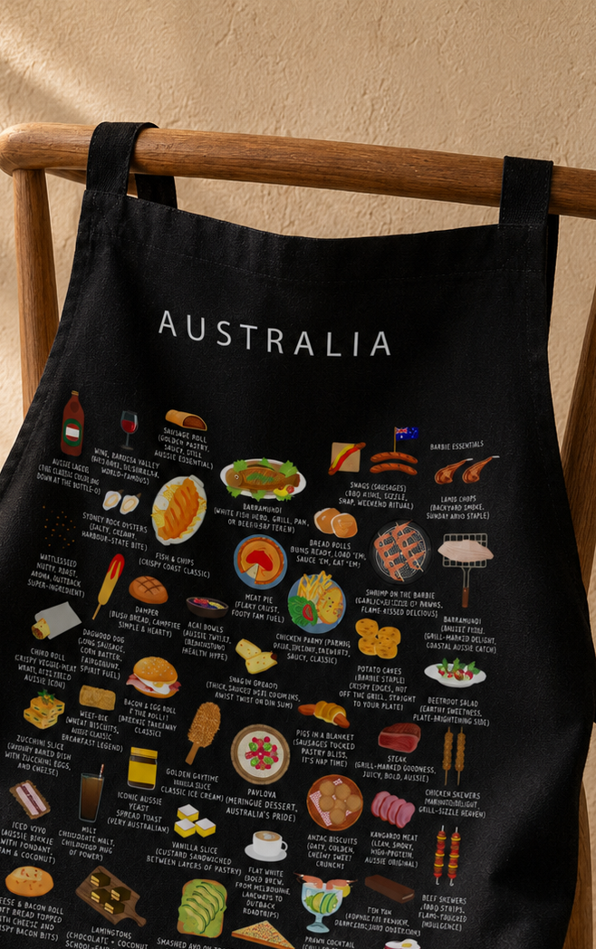 Black Australia food apron styled over a wooden chair in warm afternoon light