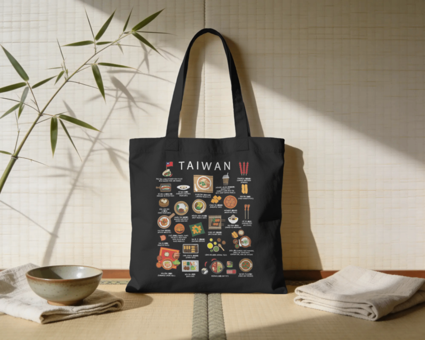 Black Taiwan food tote bag styled against a tatami mat with soft bamboo shadows