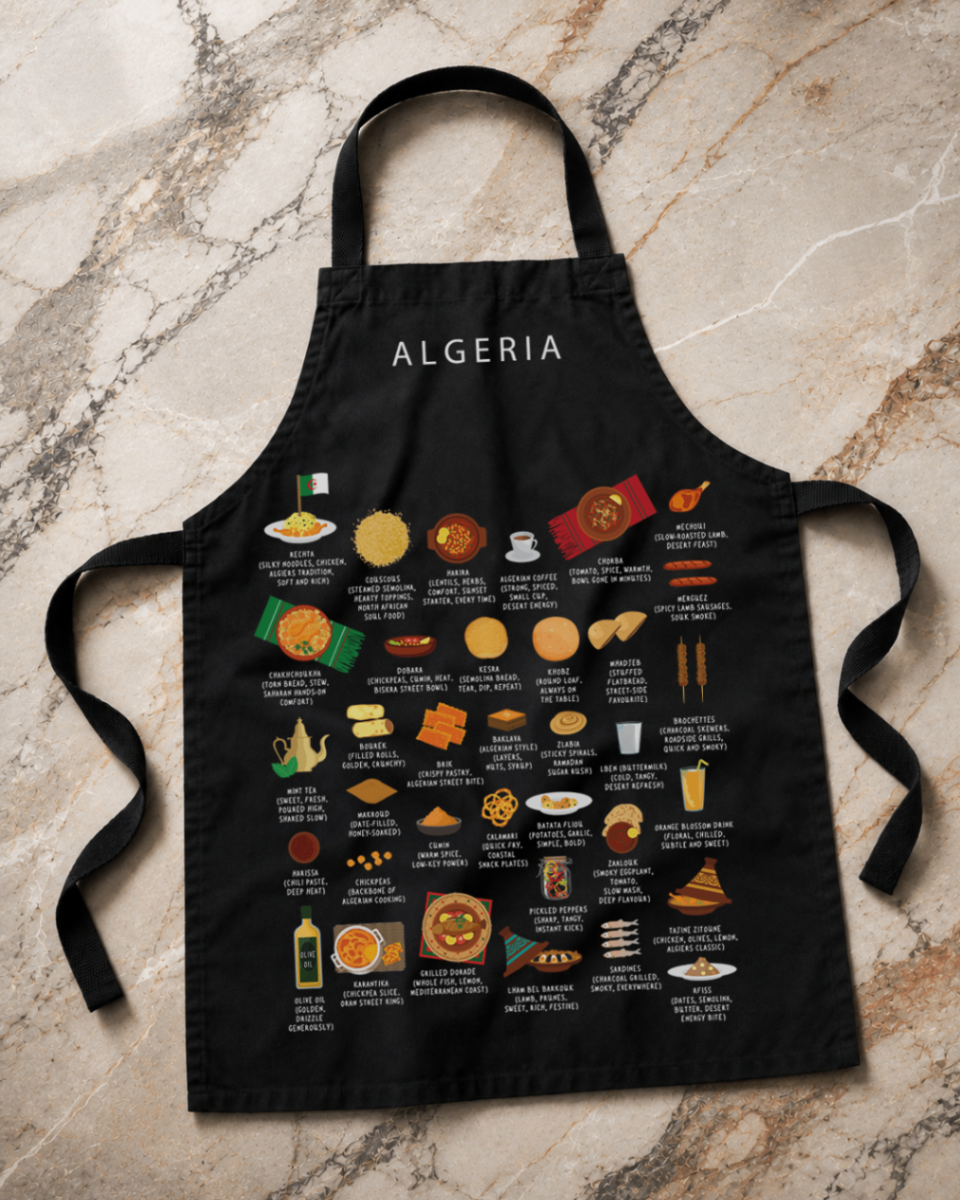 Black Algeria food apron laid flat on a marble surface in soft daylight