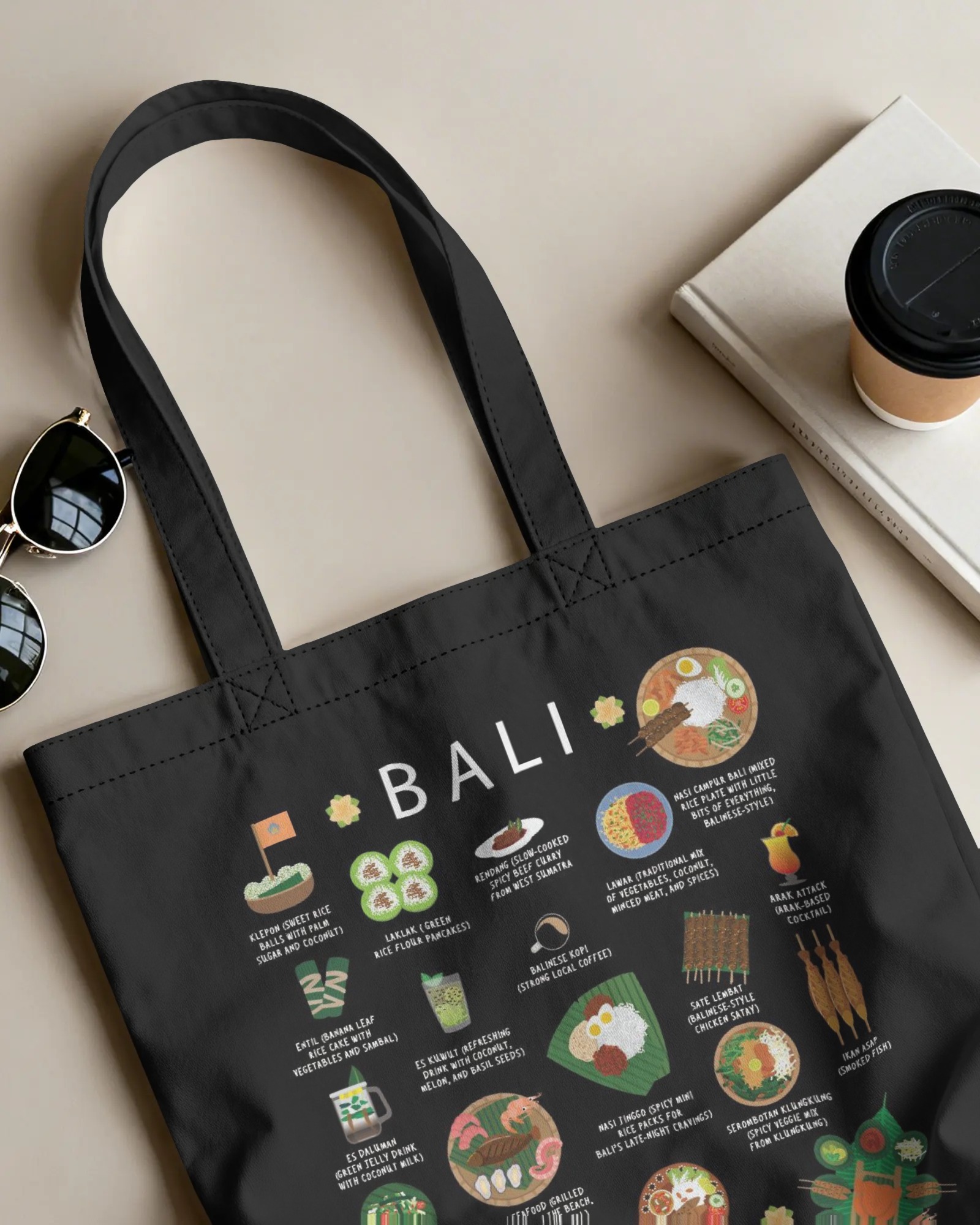 Black Bali food tote bag styled with sunglasses and a coffee cup on a neutral surface