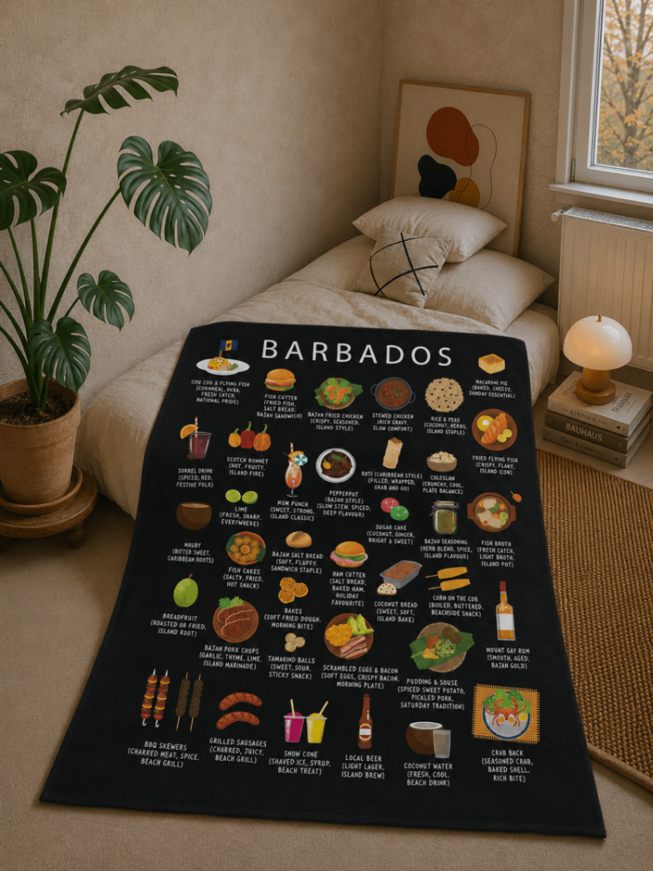 Black Barbados food blanket draped over a linen daybed in a warm plaster-walled bedroom with monstera