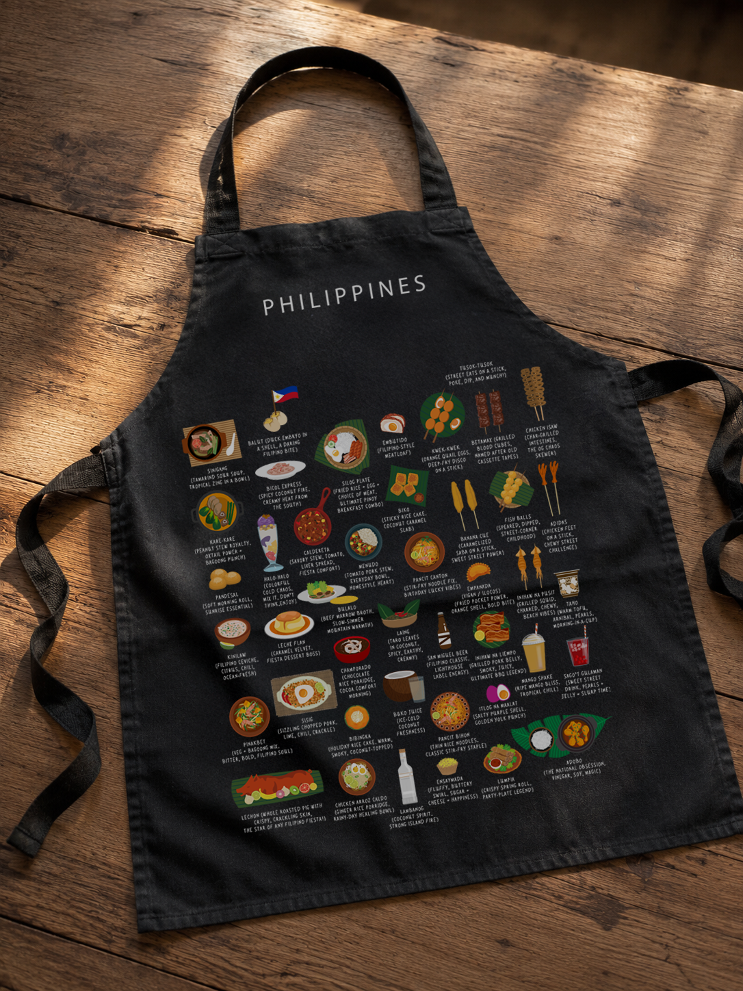 Black Philippines food apron laid on a warm wooden floor in golden light