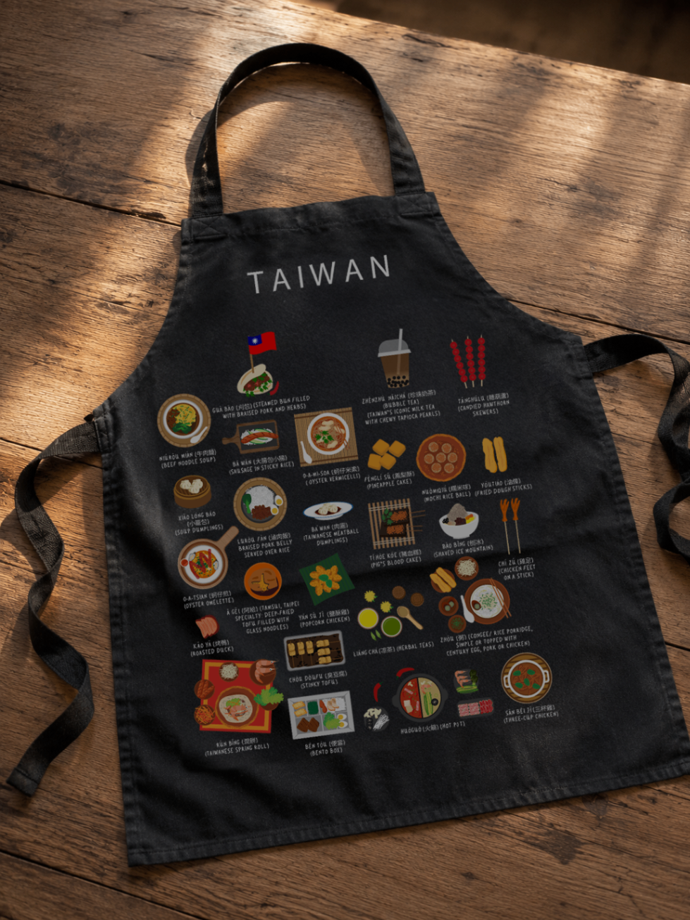 Black Taiwan food apron laid on a warm wooden floor in soft daylight