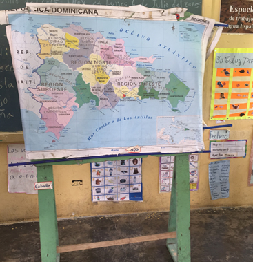 Original Maps By Annie hand-illustrated map of the Dominican Republic displayed on a wooden easel in a local school classroom.