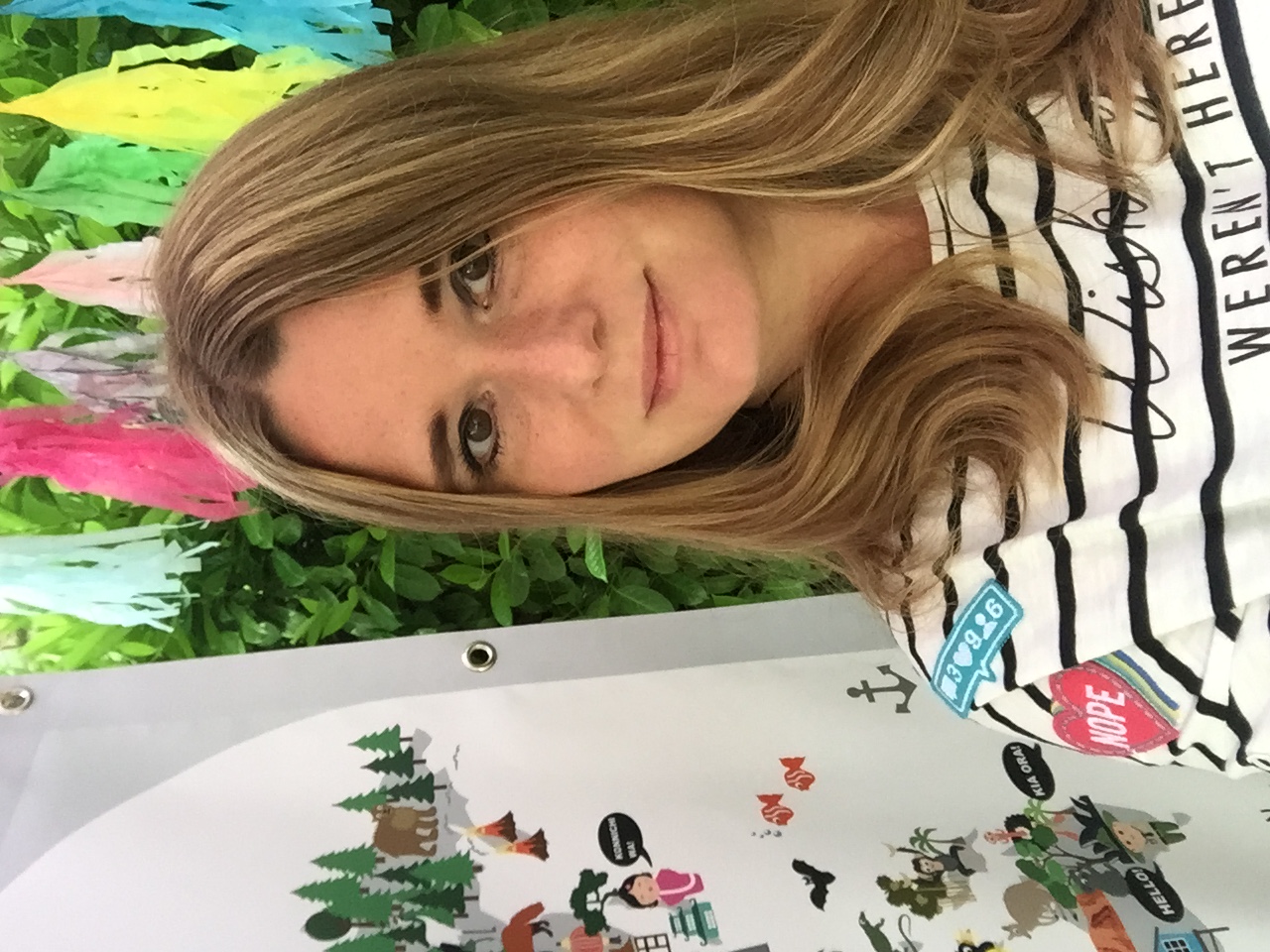 Anneke, founder of Maison Maps, photographed beside an early illustrated world map with a Konnichiwa speech bubble and colourful paper tassels in the background.