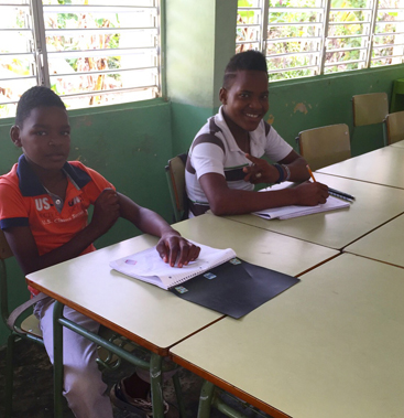 Students working on illustrated exercises in a Dominican Republic classroom, part of the early Maps By Annie community programme.