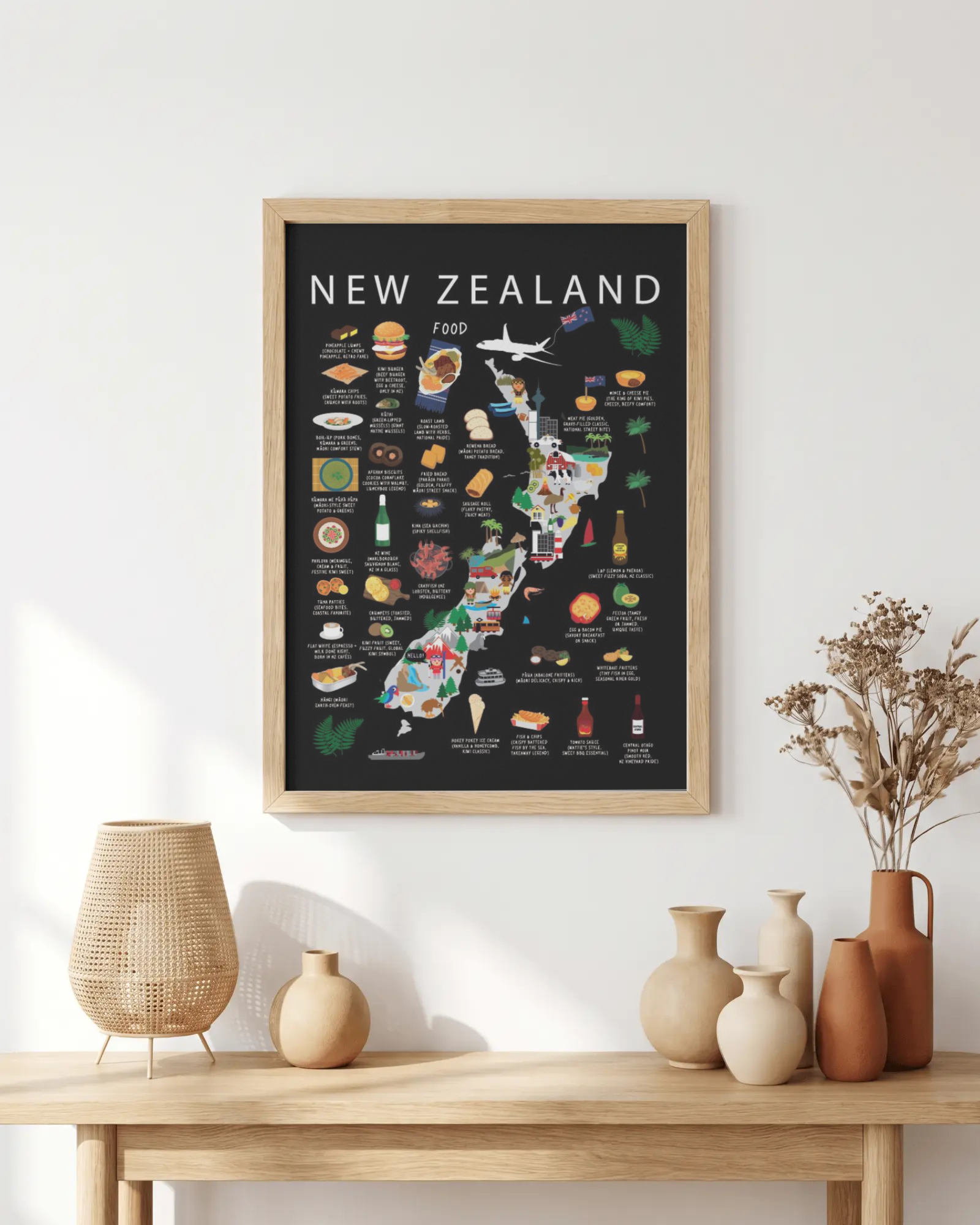 Illustrated New Zealand kids map poster in an oak frame above a wooden console