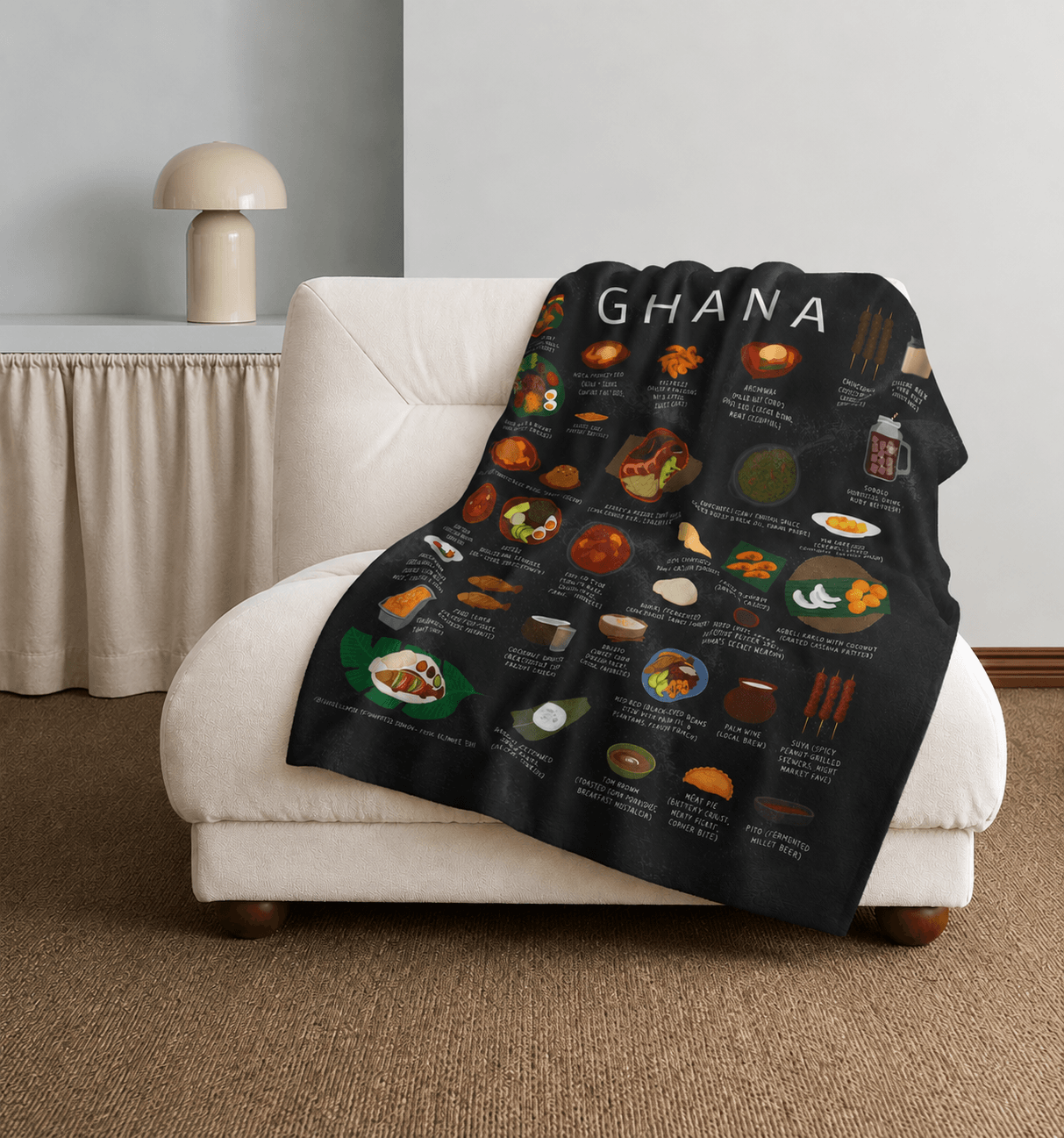 Black Ghana food blanket draped over a cream lounge chair beside a mushroom lamp