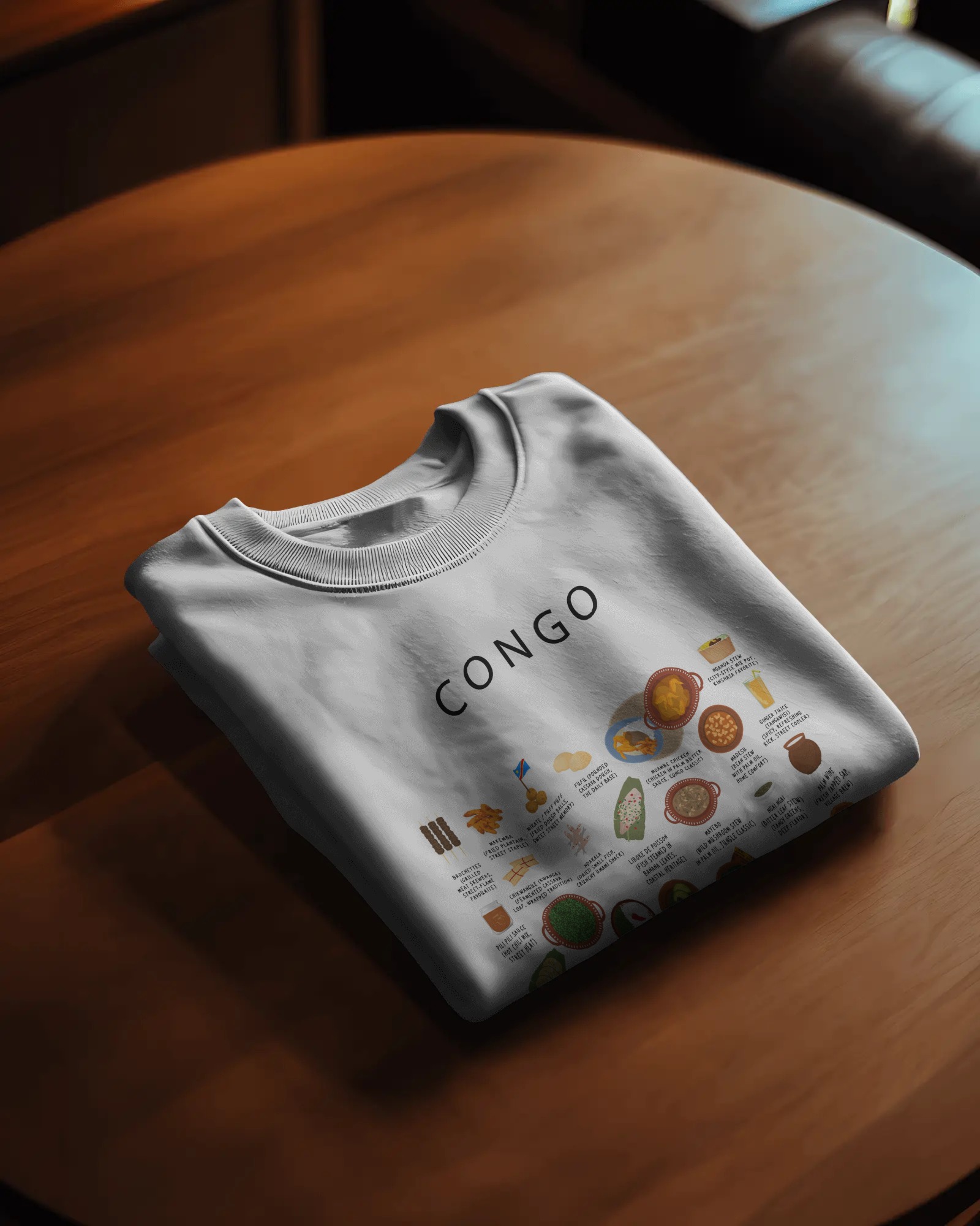 White Congo food sweater folded on a round wooden table in warm evening light