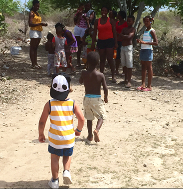 A child in a striped shirt walking towards new friends along a country path — an image evoking the spirit of Maison Maps journeys.