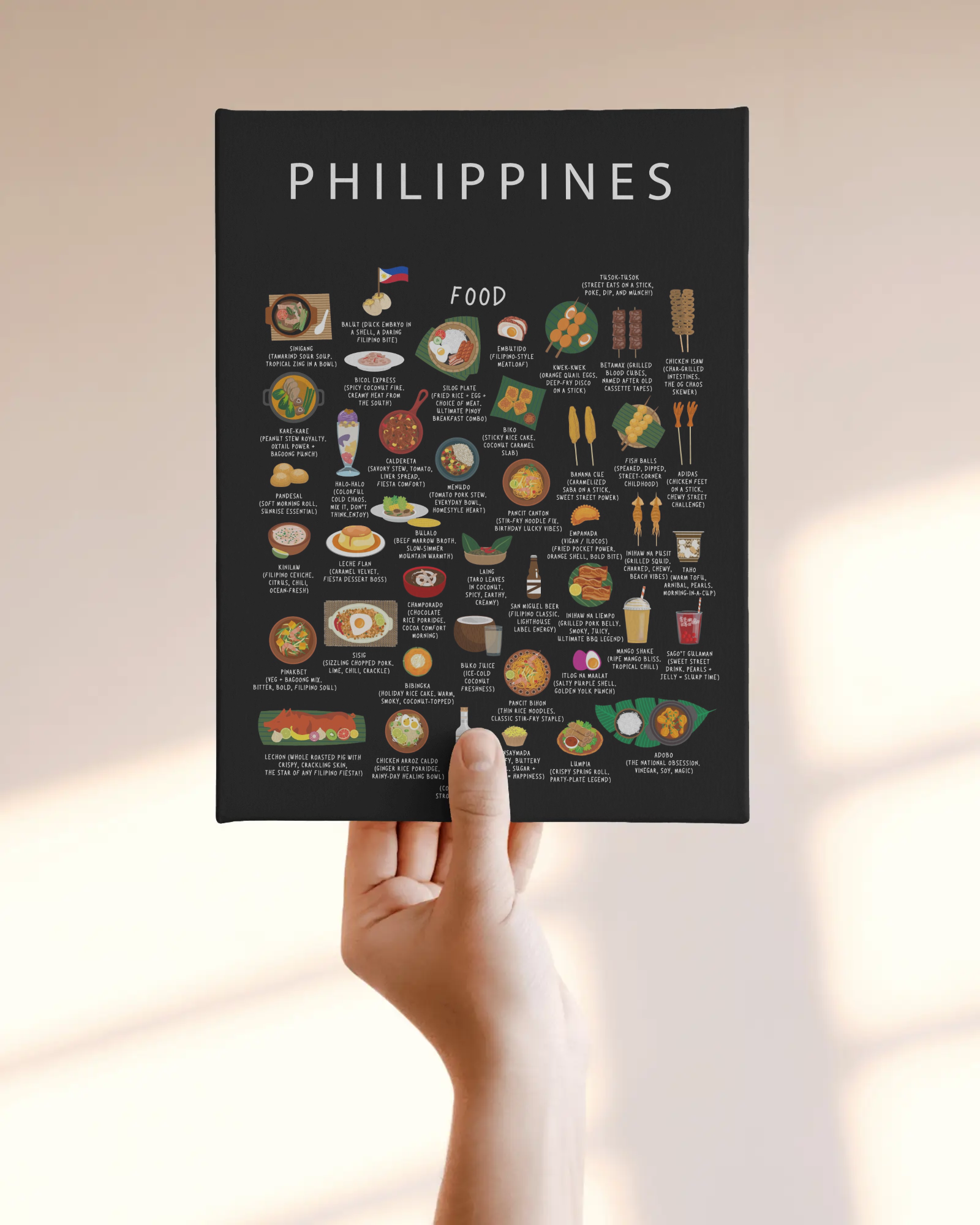 Black Philippines food poster held against a soft neutral wall in warm daylight