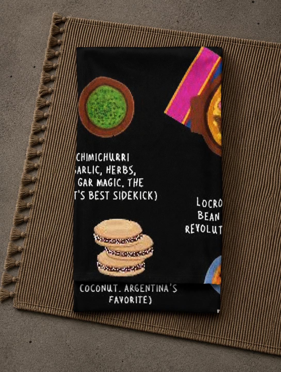 Folded Argentina food blanket photographed close-up showing chimichurri and alfajores illustrations